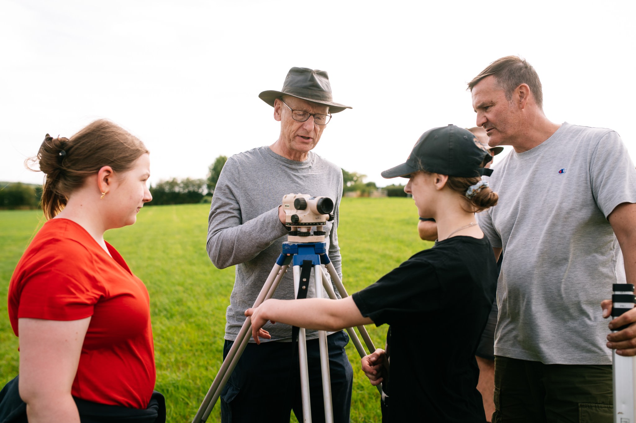 archaeology field school delegates using a dumpy level for surveying
