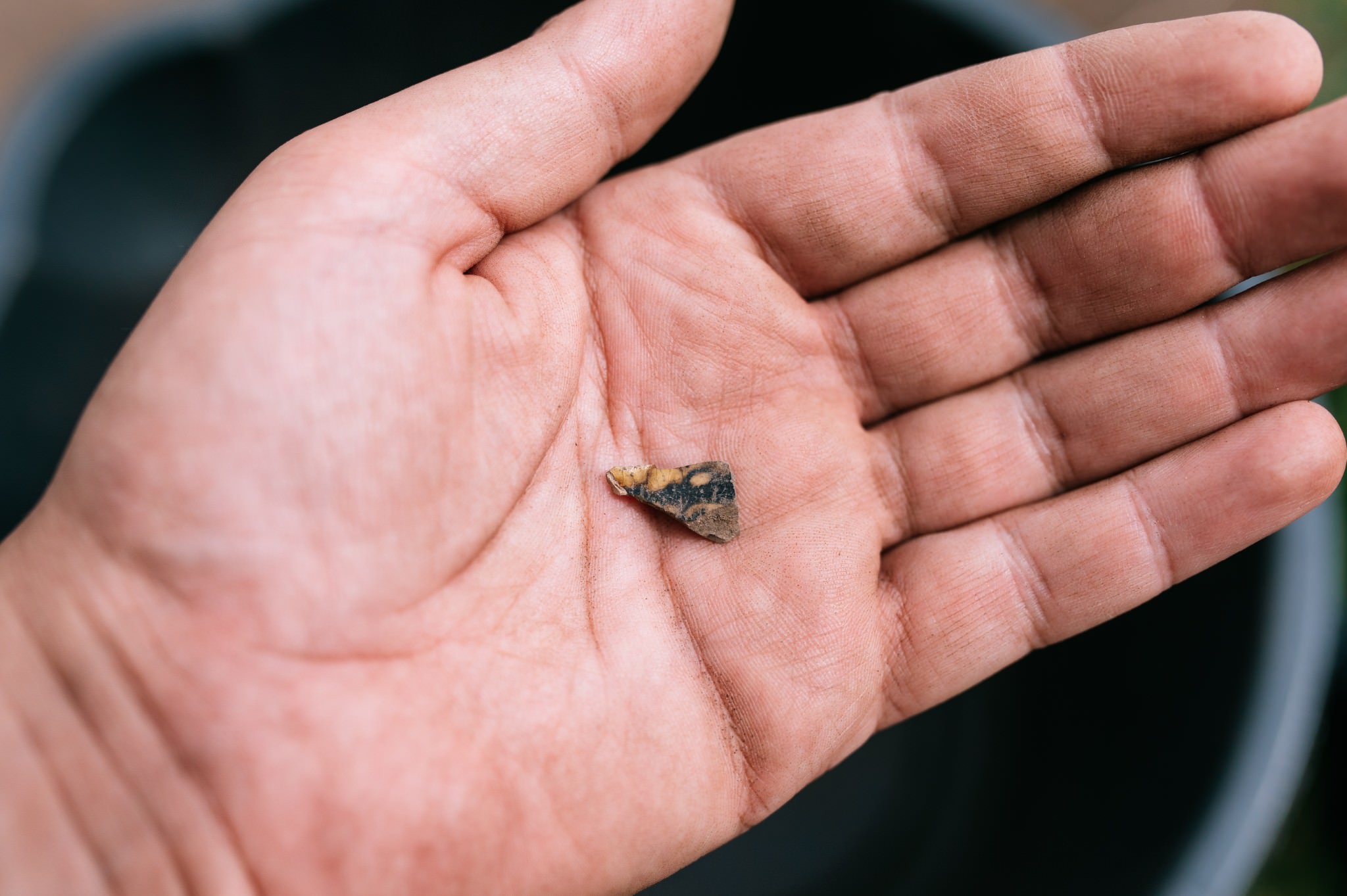 close up of a decorated piece of pot sat in the palm of a hand