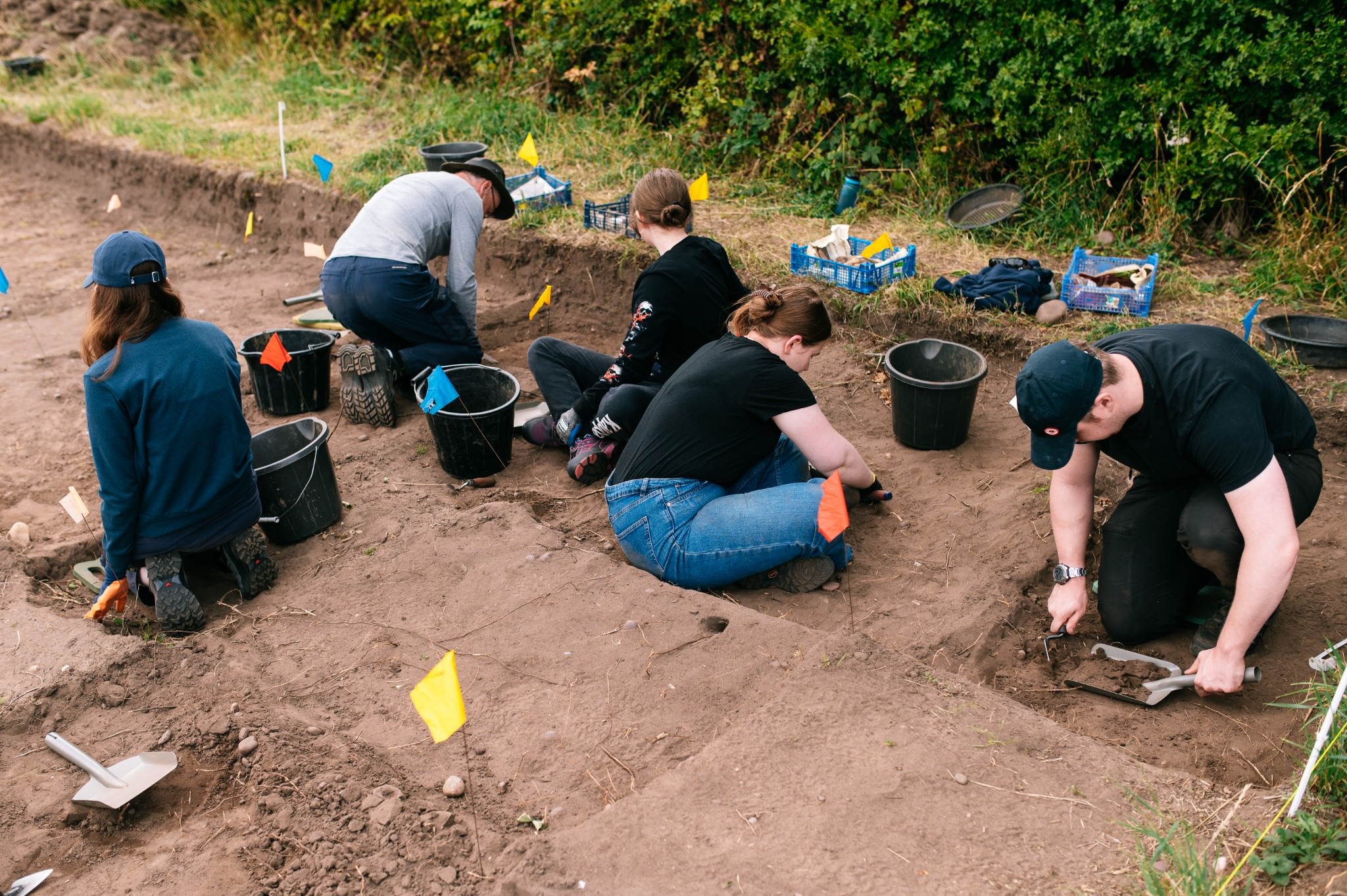 a group of students excavating in an archaeological trench
