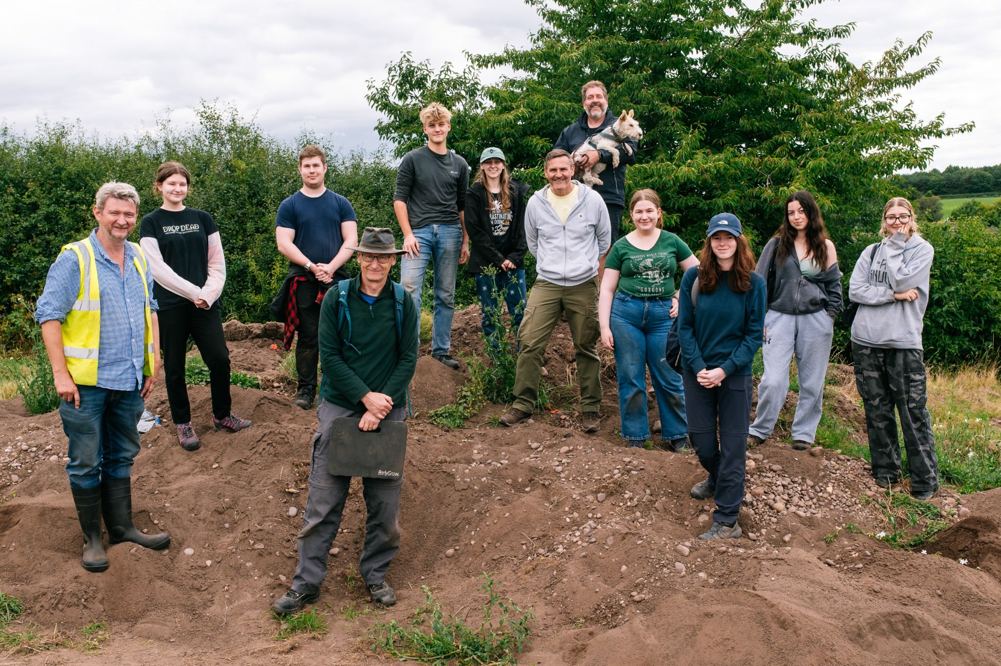 group of people stood on a spoil pile after an archaeological field school